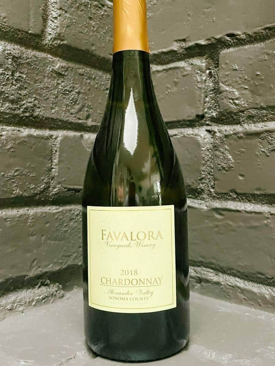 Favalora 2018 Chardonnay bottle against a grey brick backdrop