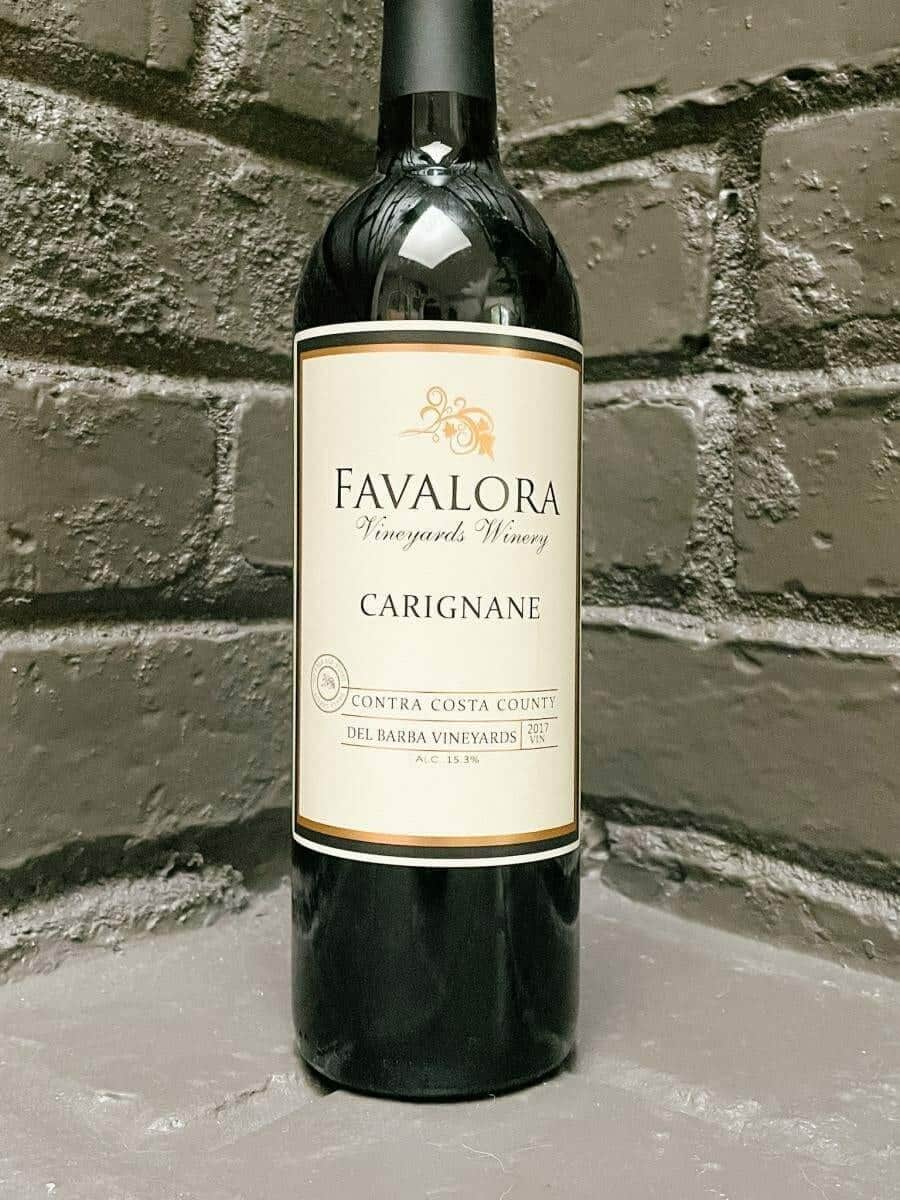 Favalora 2017 Carignane bottle against a grey brick backdrop