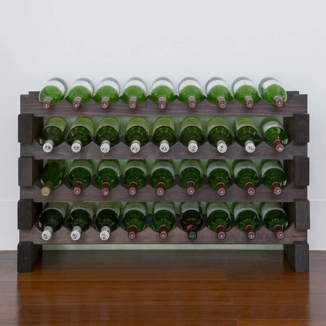 Stained modular wine rack holding green wine bottles