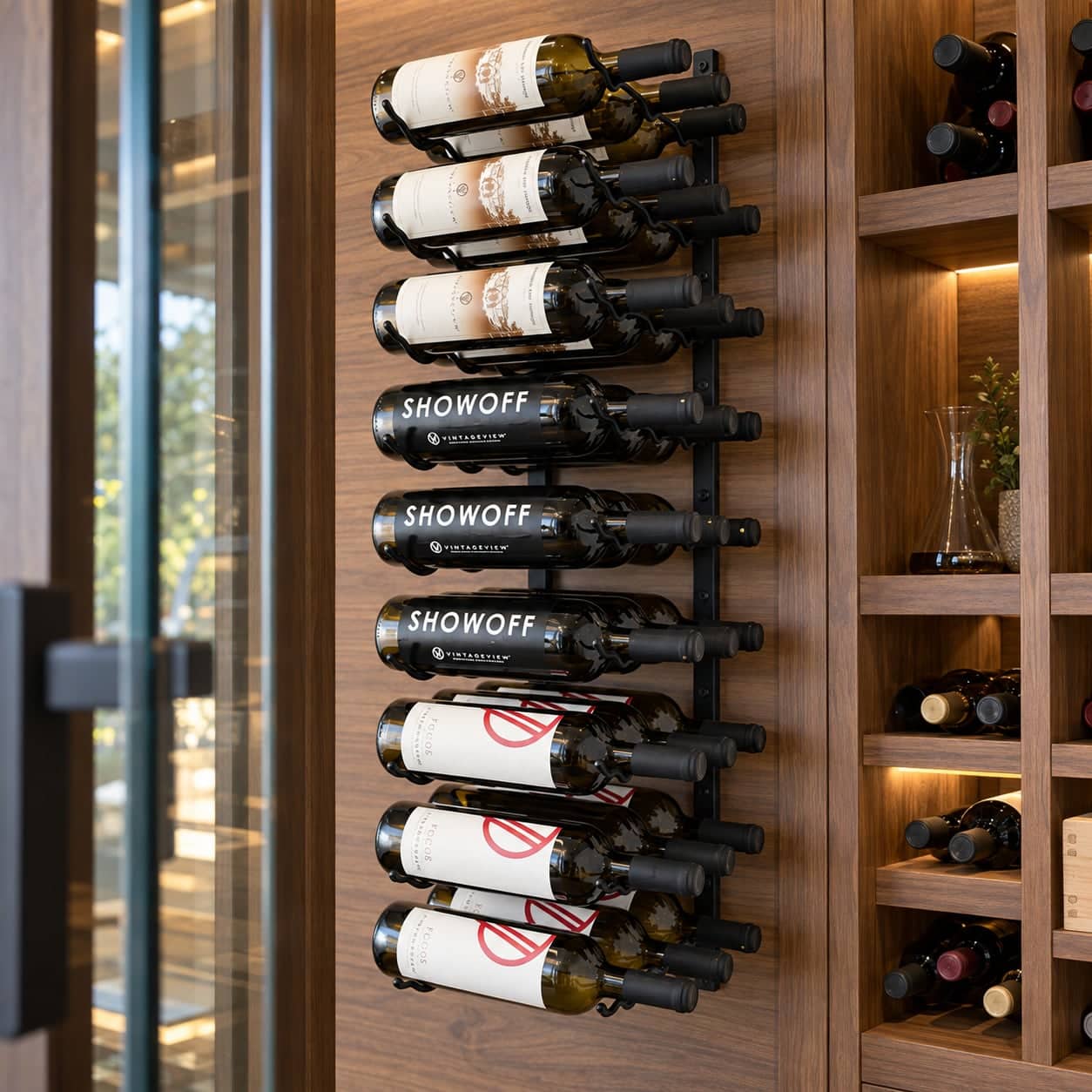 Close-up of wall-mounted VintageView bottle racks beside a glass cellar door and wood shelving