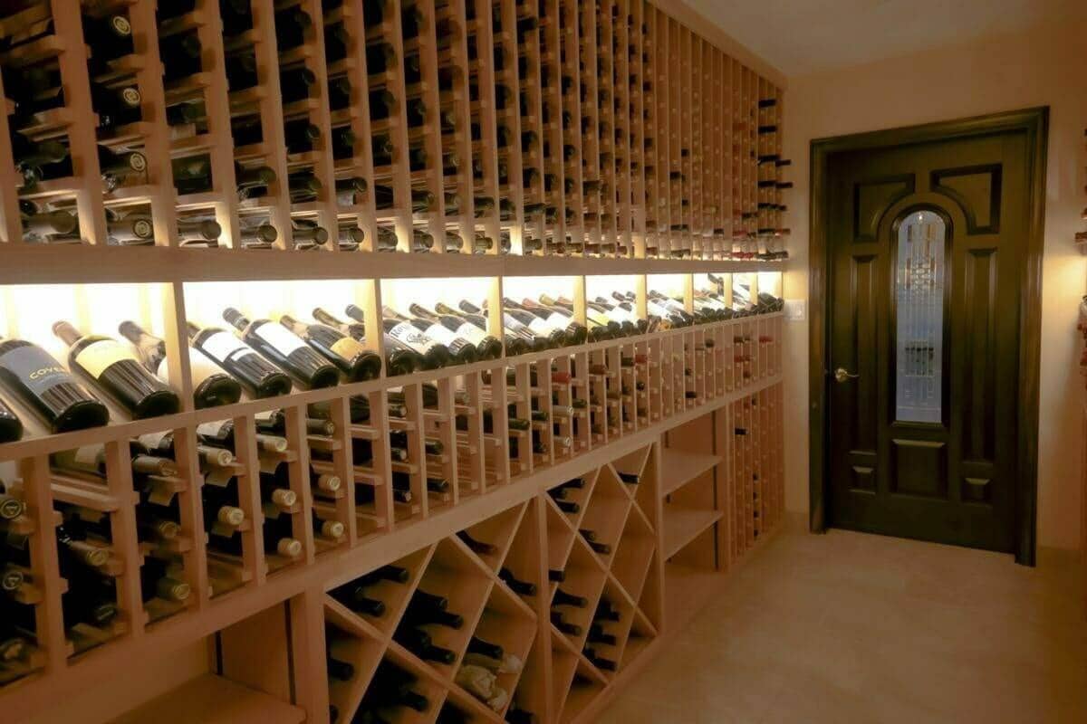 Wooden bottle racks combine individual slots, an illuminated display row and diamond bins.