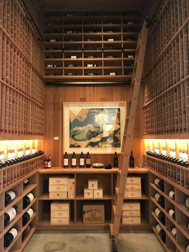 A rolling ladder reaches tall wooden racks in the Larkmead wine library.