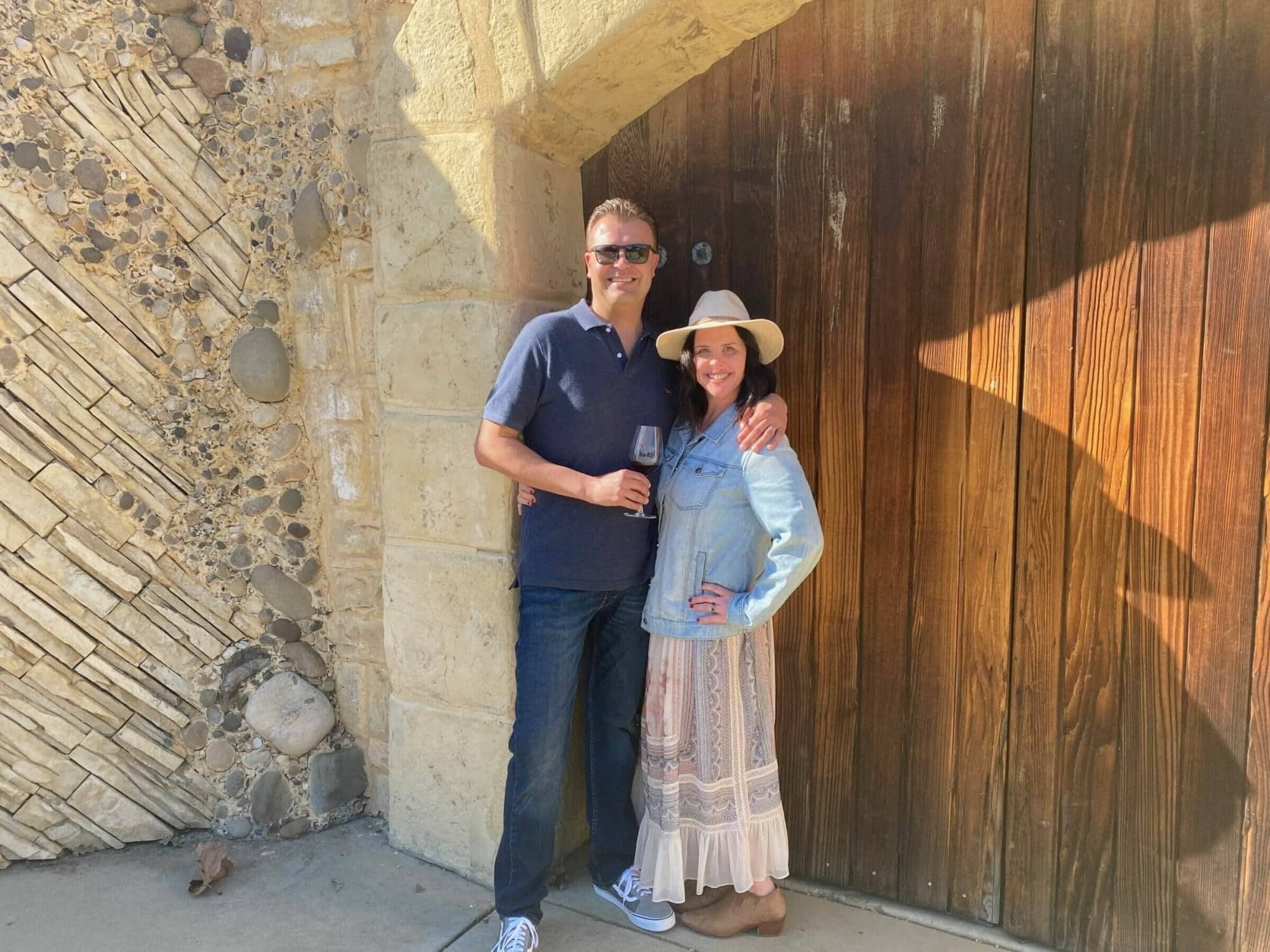 Man and woman standing together at a stone and wood entryway