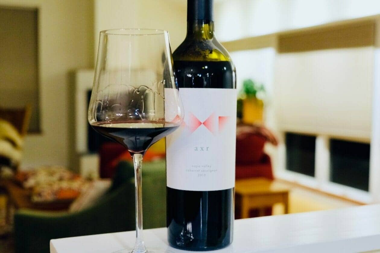 AXR wine bottle and poured glass on a table in a furnished living room