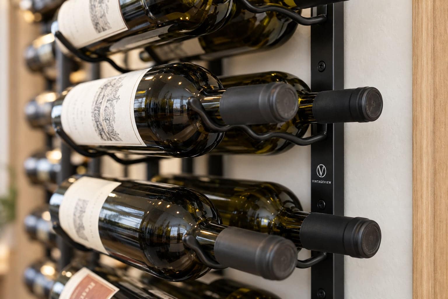 Close-up of bottle necks in a VintageView metal wall rack showing the logo