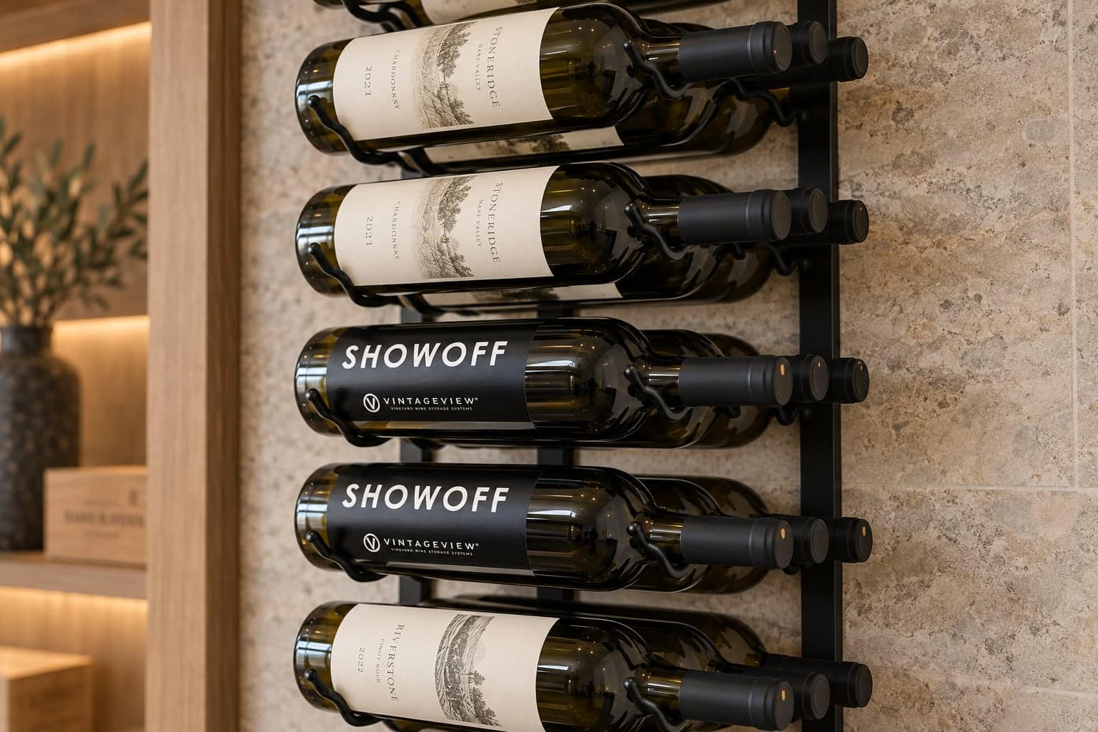 Close-up of labeled Stoneridge and Showoff wine bottles in a black VintageView wall rack
