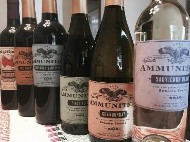 Row of six Ammunition wine bottles lined up on a woven table runner