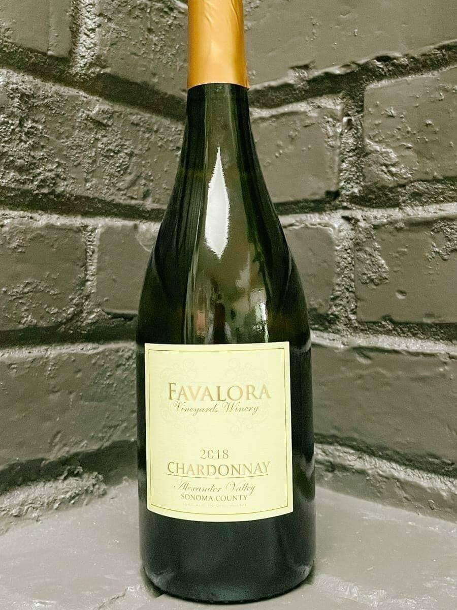 Favalora 2018 Chardonnay bottle against a grey brick backdrop