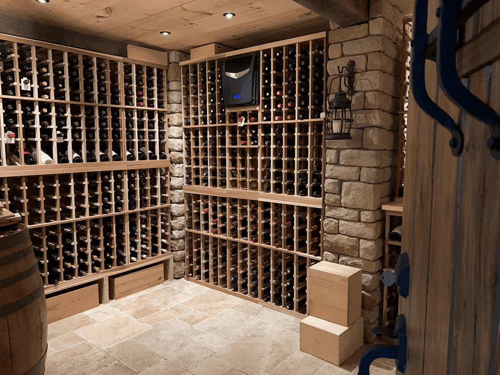 A finished wine cellar with wood racks, stone pillars, and a wall lantern