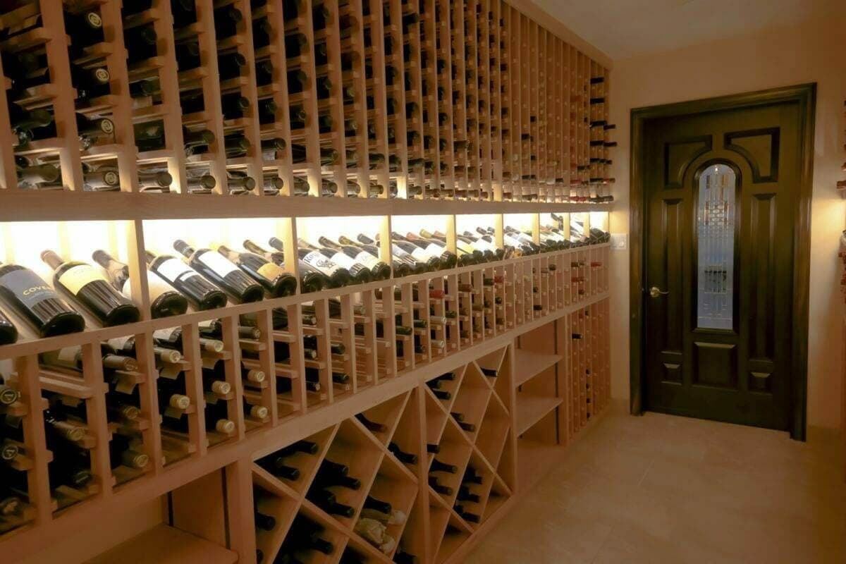 Wooden bottle racks combine individual slots, an illuminated display row and diamond bins.
