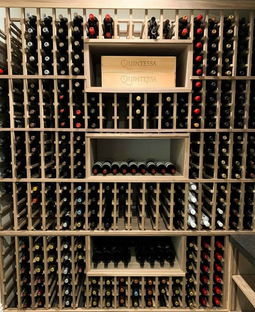 Wooden bottle slots surround open cubbies holding wine cases.