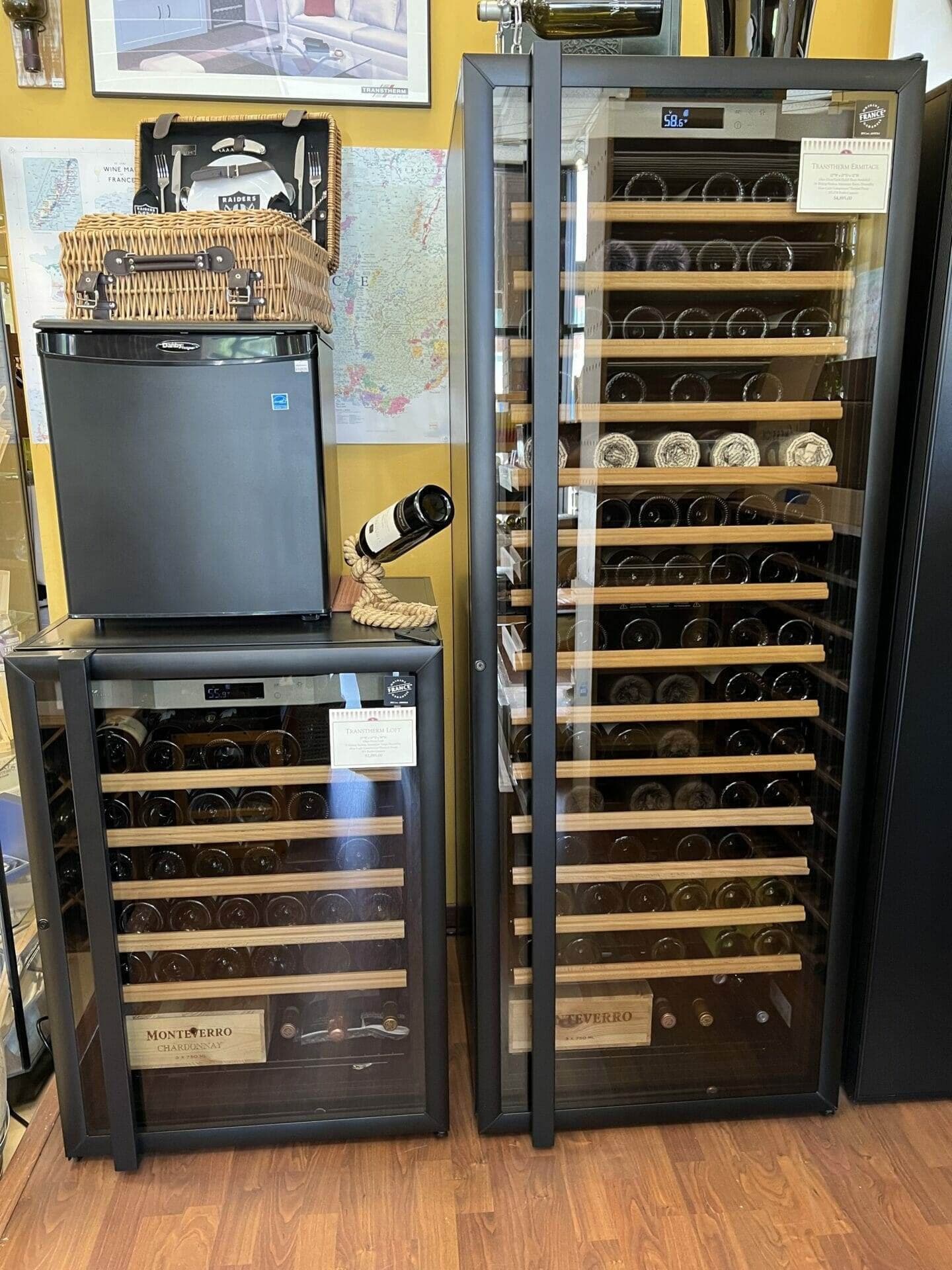 Several wine cabinets and a compact refrigerator form a showroom display.