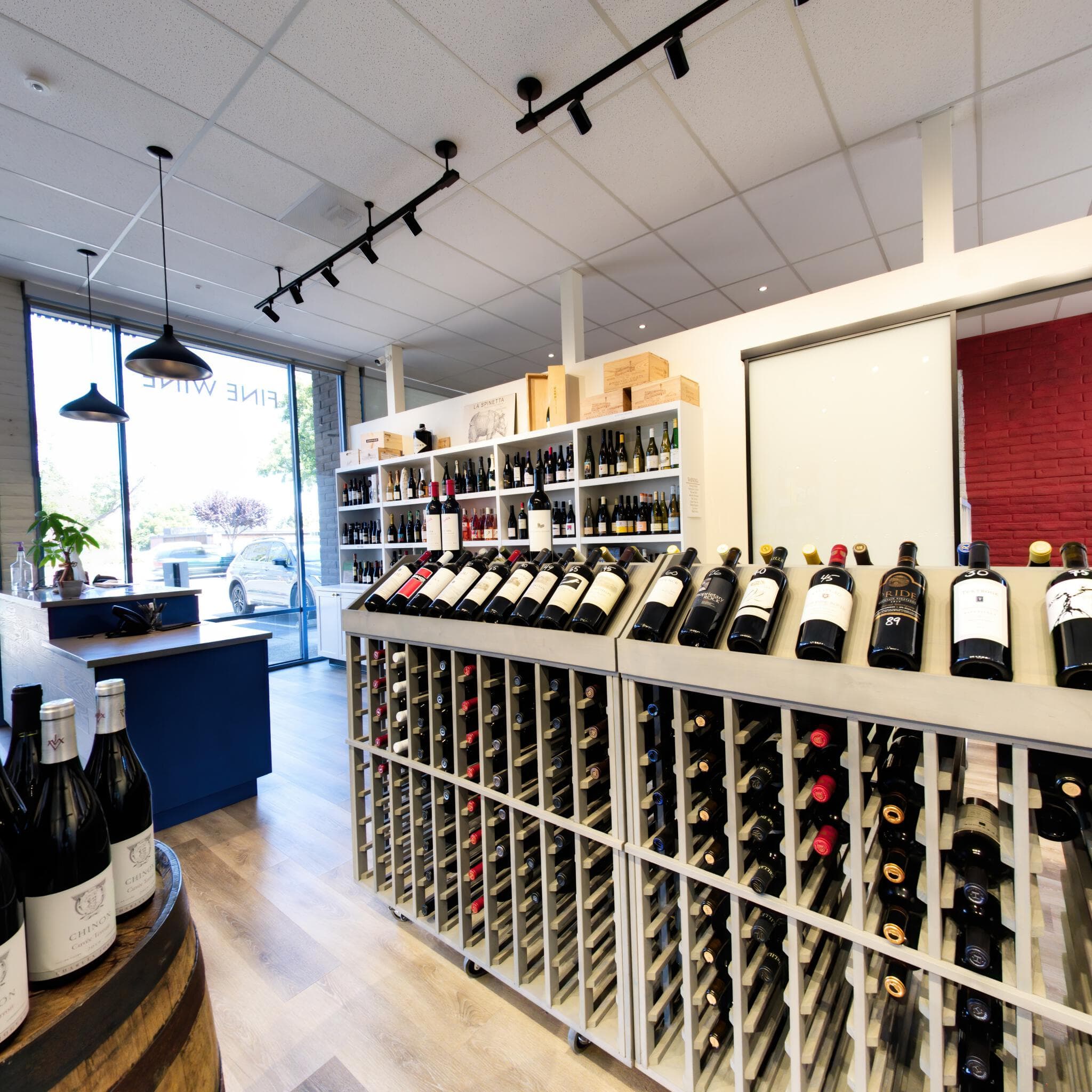 Gray-stained alder wine racks and bottle displays inside the Prima Vini wine store