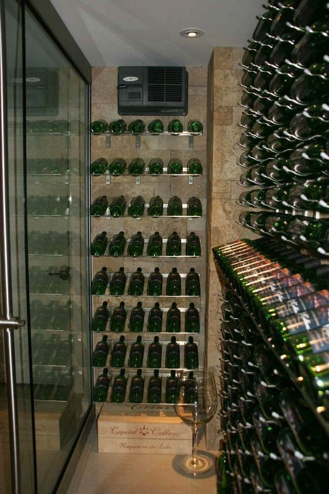 Glass-door wine cellar with stone walls and a wall-mounted cooling unit