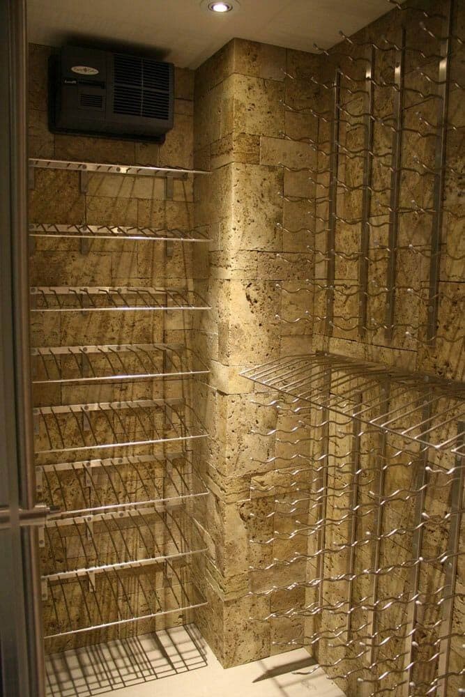 Glass-enclosed wine cellar beside a kitchen counter and pendant lighting