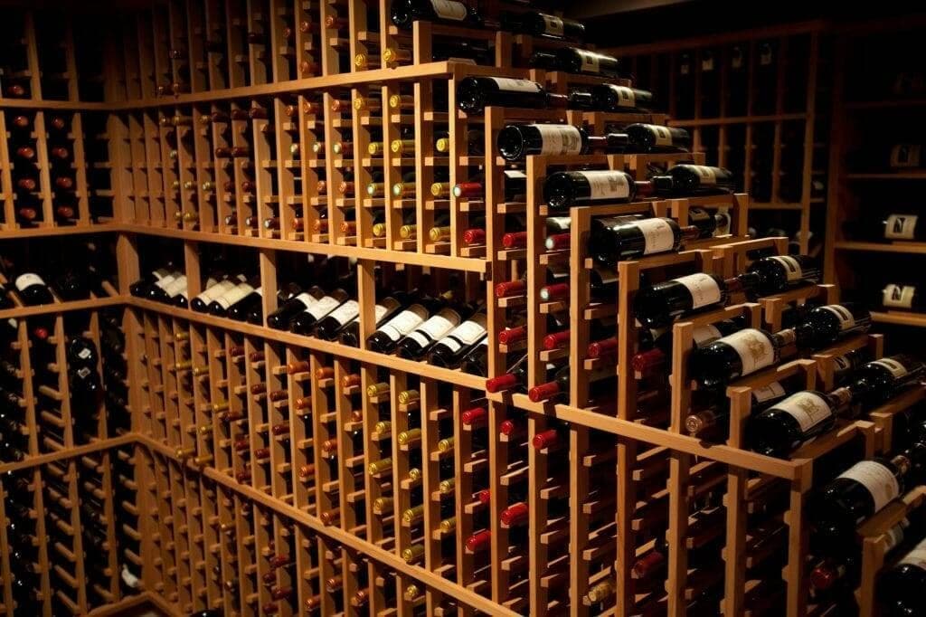 Close view of wood wine racks fully stocked with labeled bottles