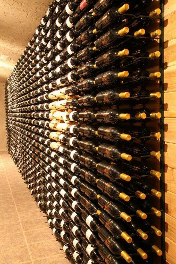 Angled corridor of wall-mounted wine racks receding into a cellar