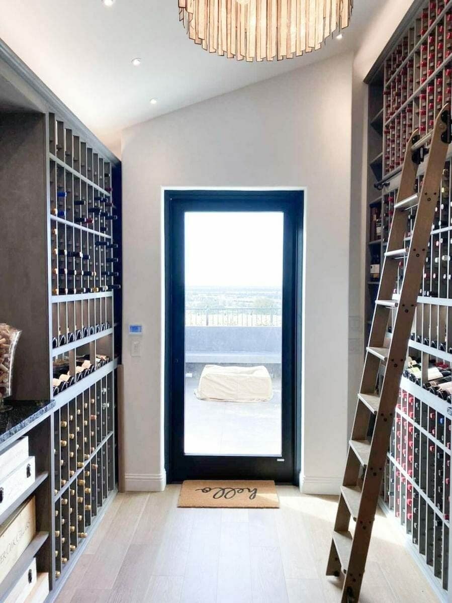 Rooftop wine cellar with a glass door opening onto a city terrace