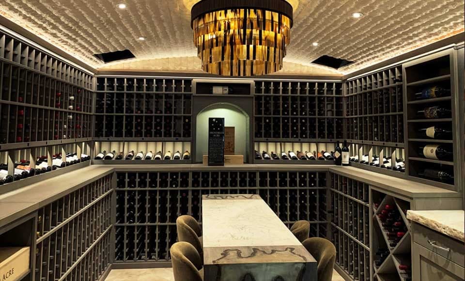 Wine cellar with barrel-stave chandelier and floor-to-ceiling bottle racks