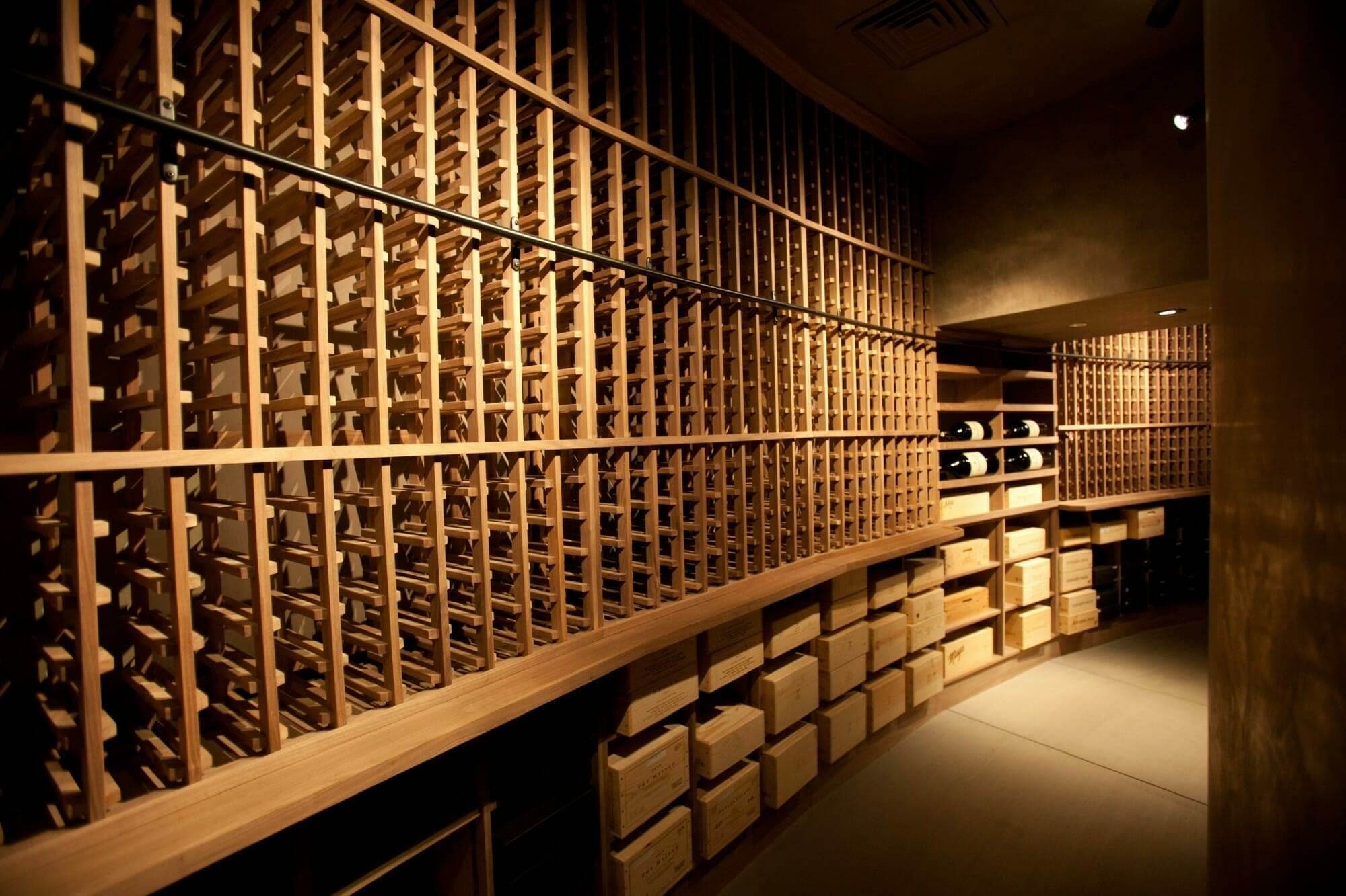 Angled view down a wine cellar row of wooden bins and storage boxes