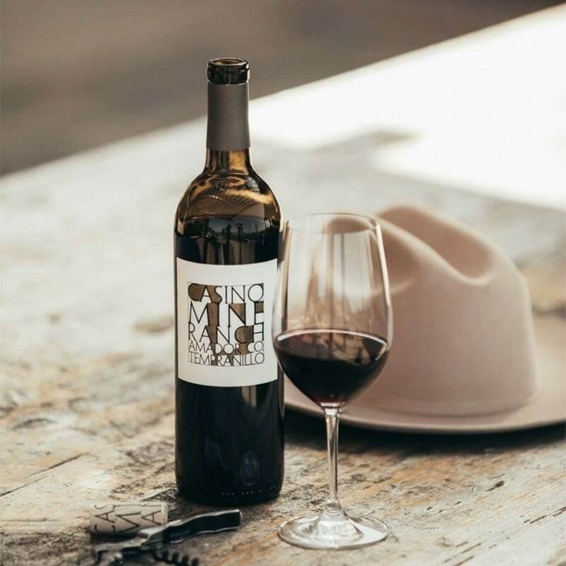 Casino Mine Ranch Tempranillo bottle and poured glass styled with a felt hat