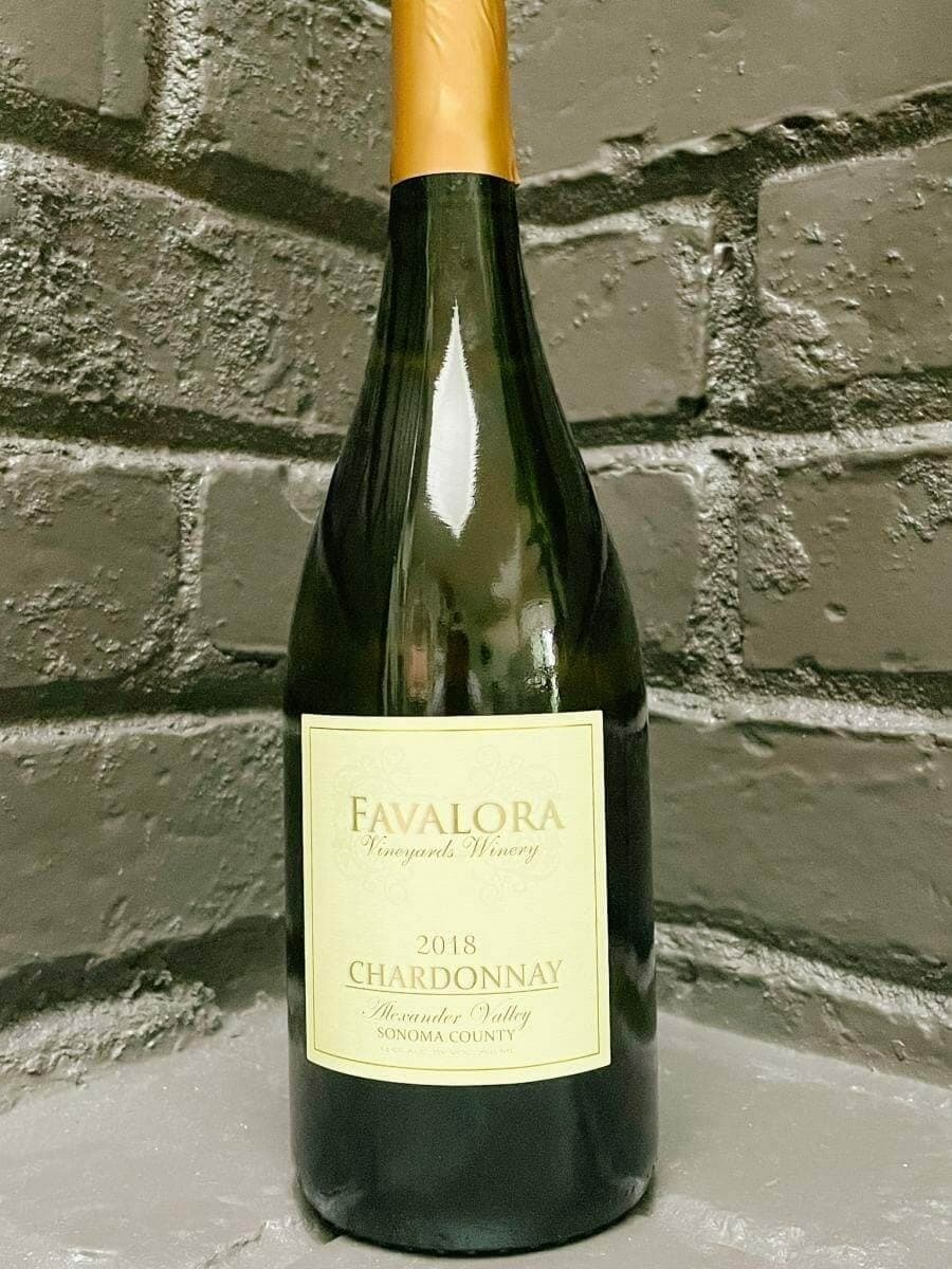 Favalora 2018 Chardonnay bottle against a grey brick backdrop