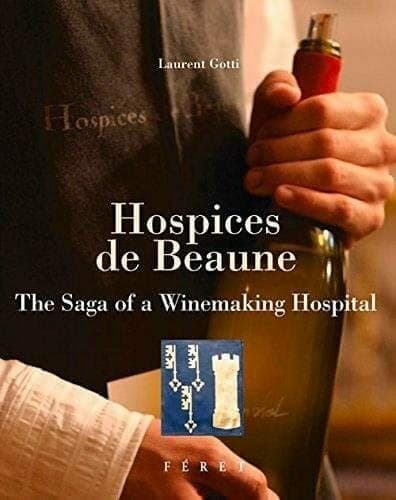 Hospices de Beaune book cover showing a hand holding a wine bottle