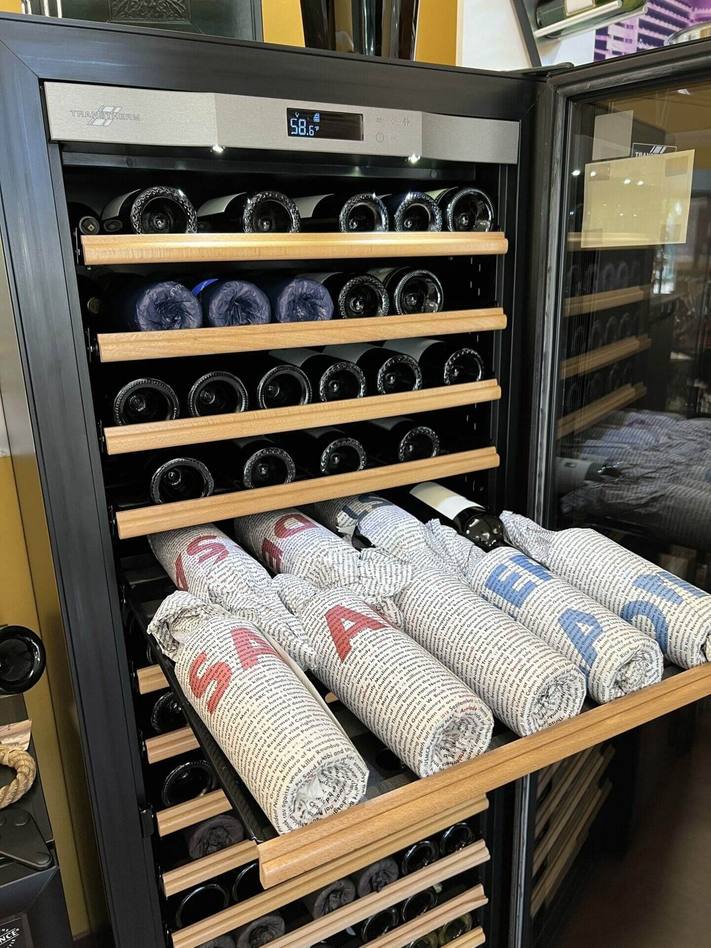 Transtherm wine cabinet with rolled cellar towels in the bottom drawer, shelves above