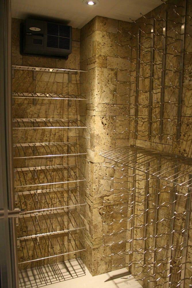 Glass-enclosed wine cellar beside a kitchen counter and pendant lighting