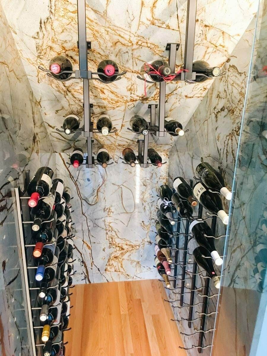 Marble-tiled wine cellar corner with ceiling and floor bottle racks