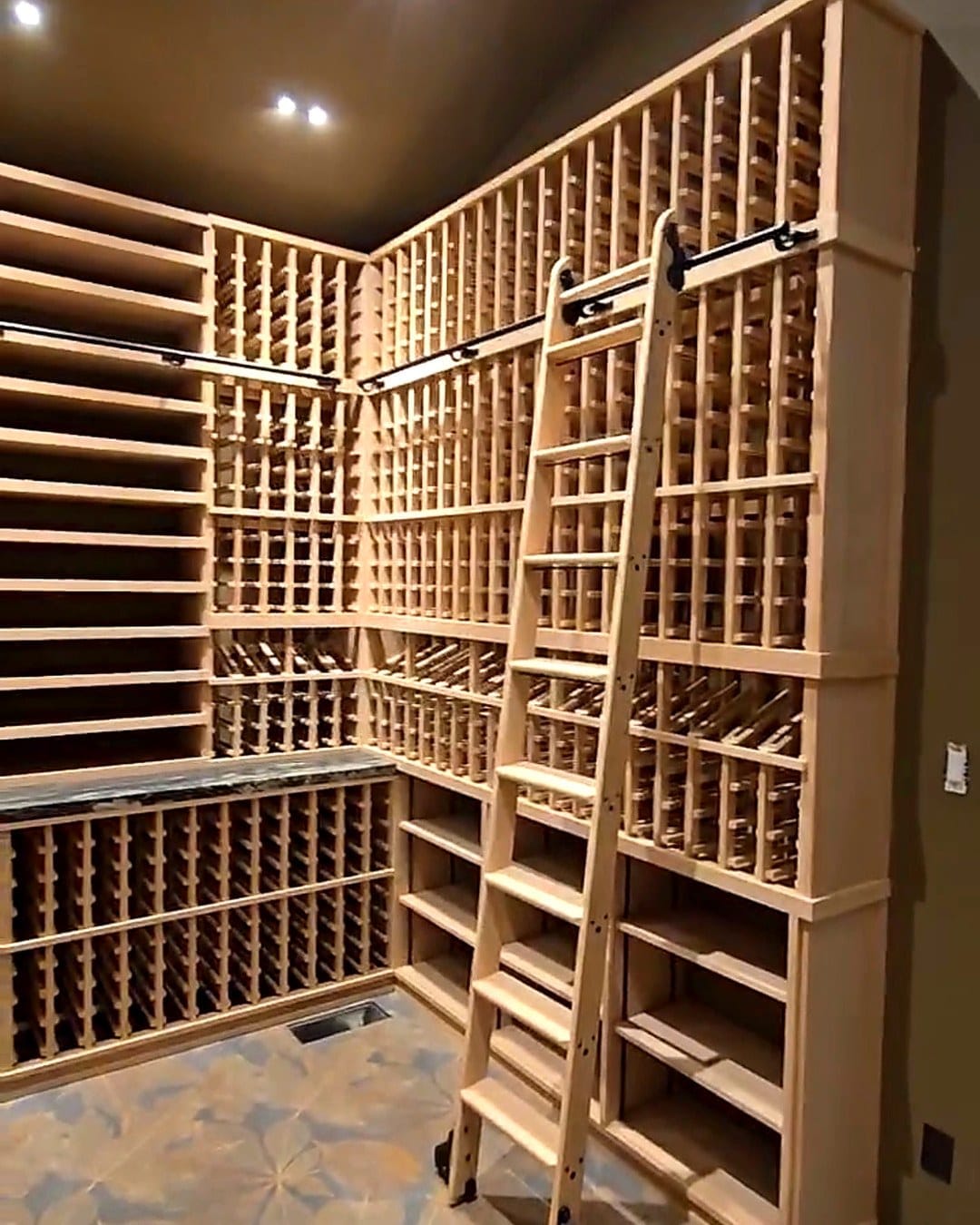 Custom light-wood wine cellar with rolling ladder and floor-to-ceiling racking