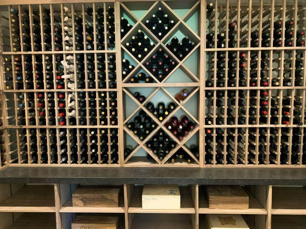 Wooden diamond bins divide a wall of individual bottle slots above case cubbies.