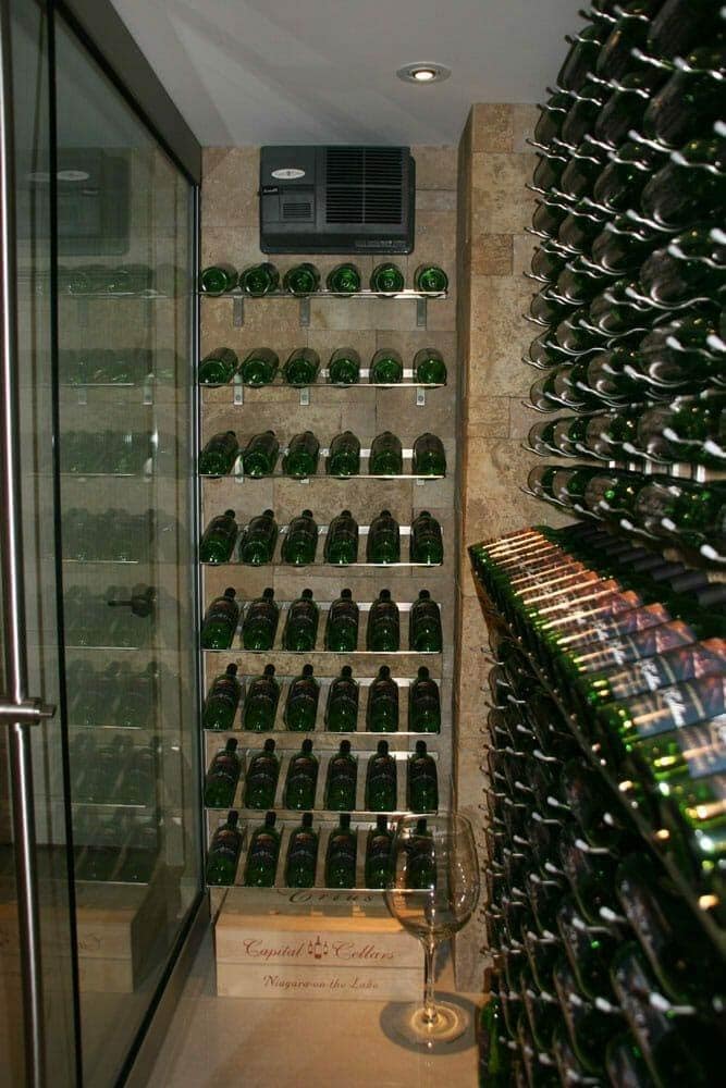 Glass-door wine cellar with stone walls and a wall-mounted cooling unit