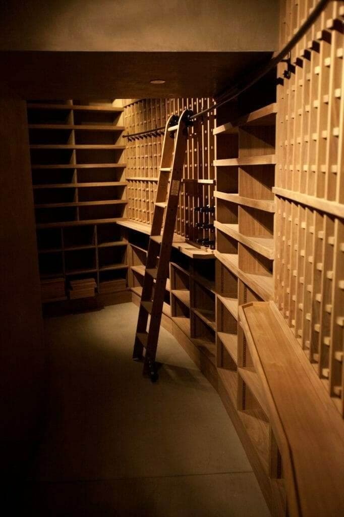 Wine cellar corridor with sloped ceiling and stocked wood racks