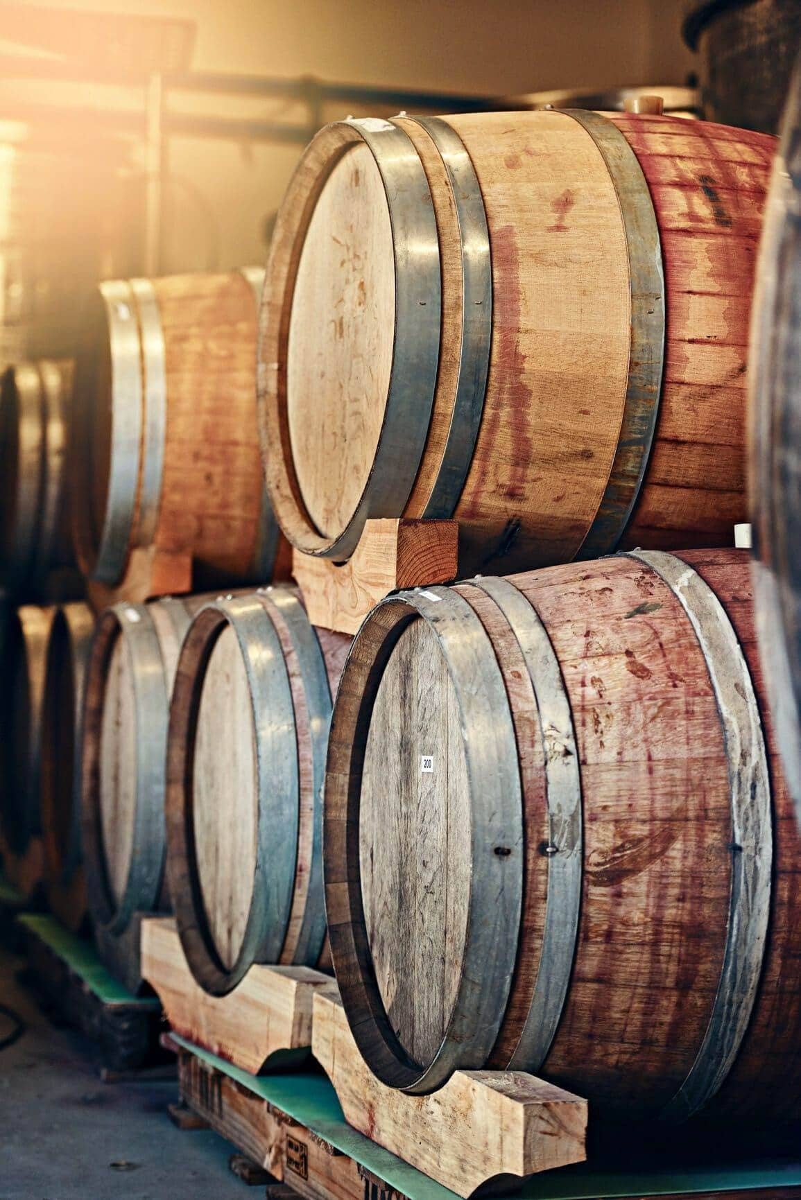 Stacked wine barrels lit warmly inside the Walnut Creek showroom