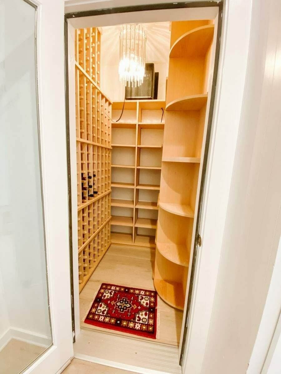 Walk-in wine closet with diamond bins, open shelving and a patterned rug