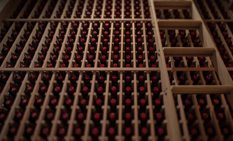 Close-up of stacked wine bottles in a diamond wood storage rack