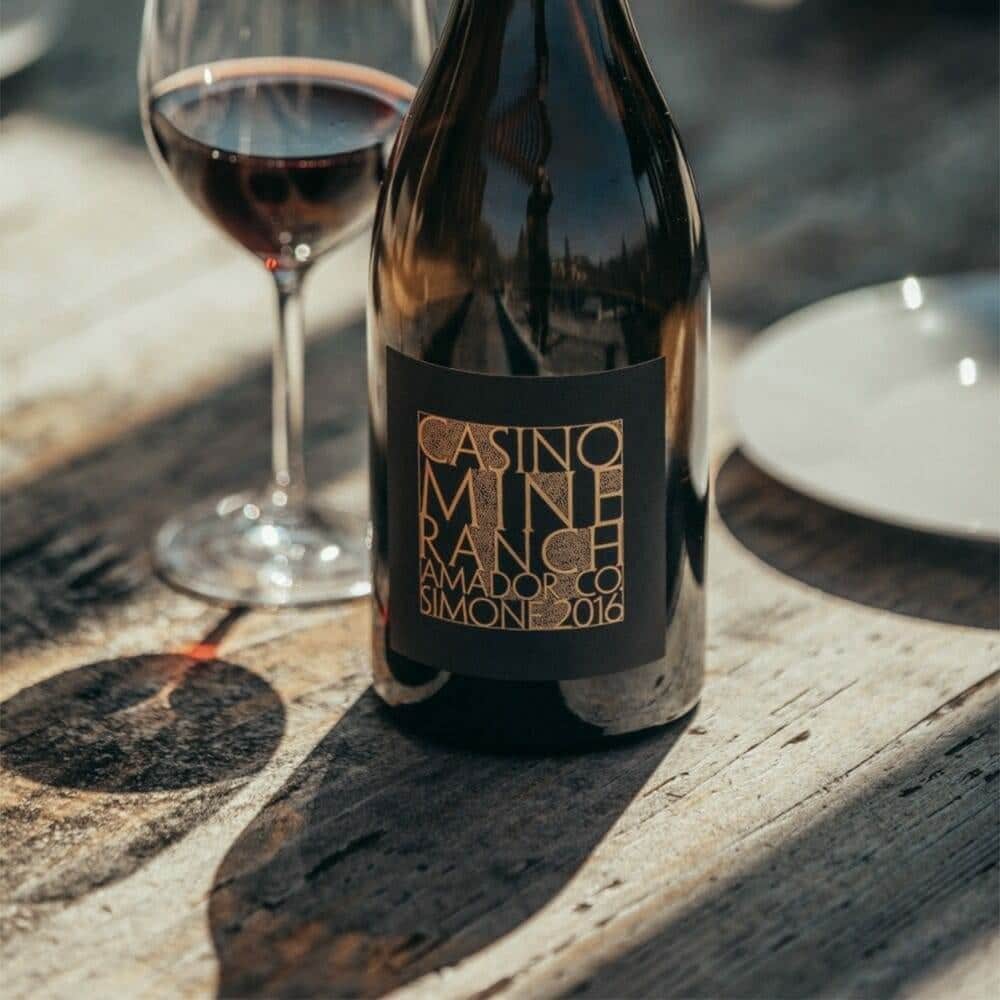 Casino Mine Ranch Simone bottle and glass styled on a weathered wood table