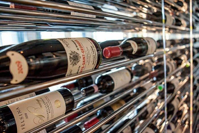 Close-up of wine bottles resting on an Evolution chrome wine rack