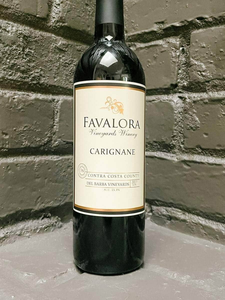 Favalora 2017 Carignane bottle against a grey brick backdrop
