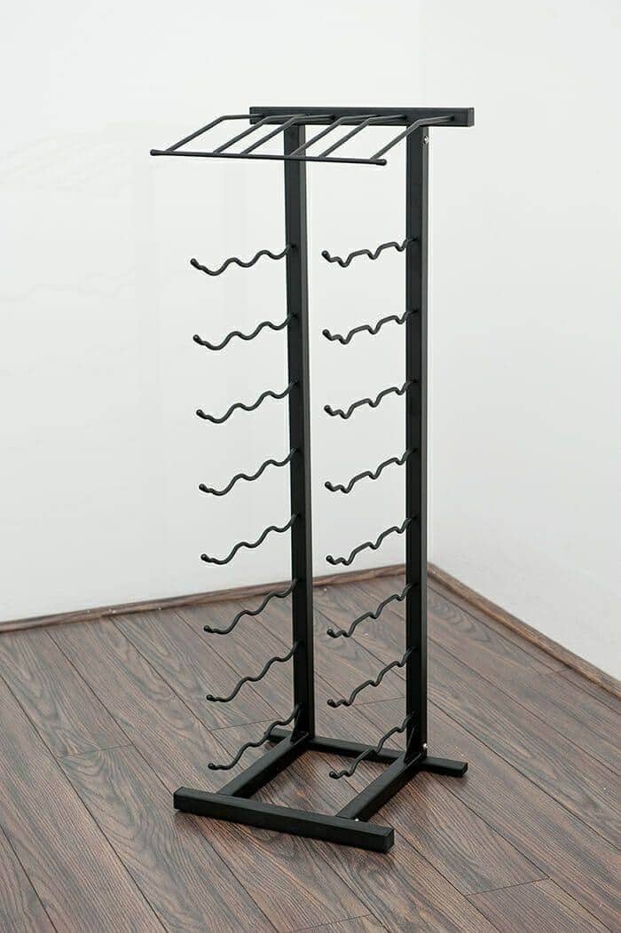 Satin black floor wine rack holding 27 bottles on wood floor