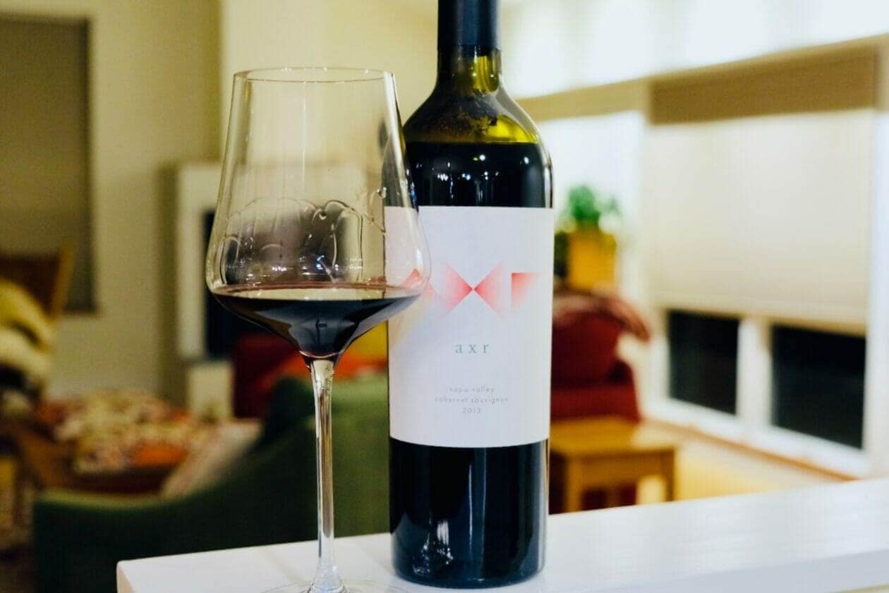 AXR wine bottle and poured glass on a table in a furnished living room