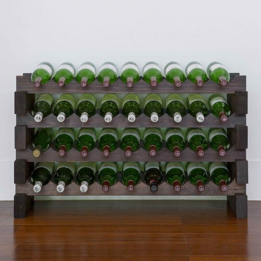 Stained modular wine rack holding green wine bottles