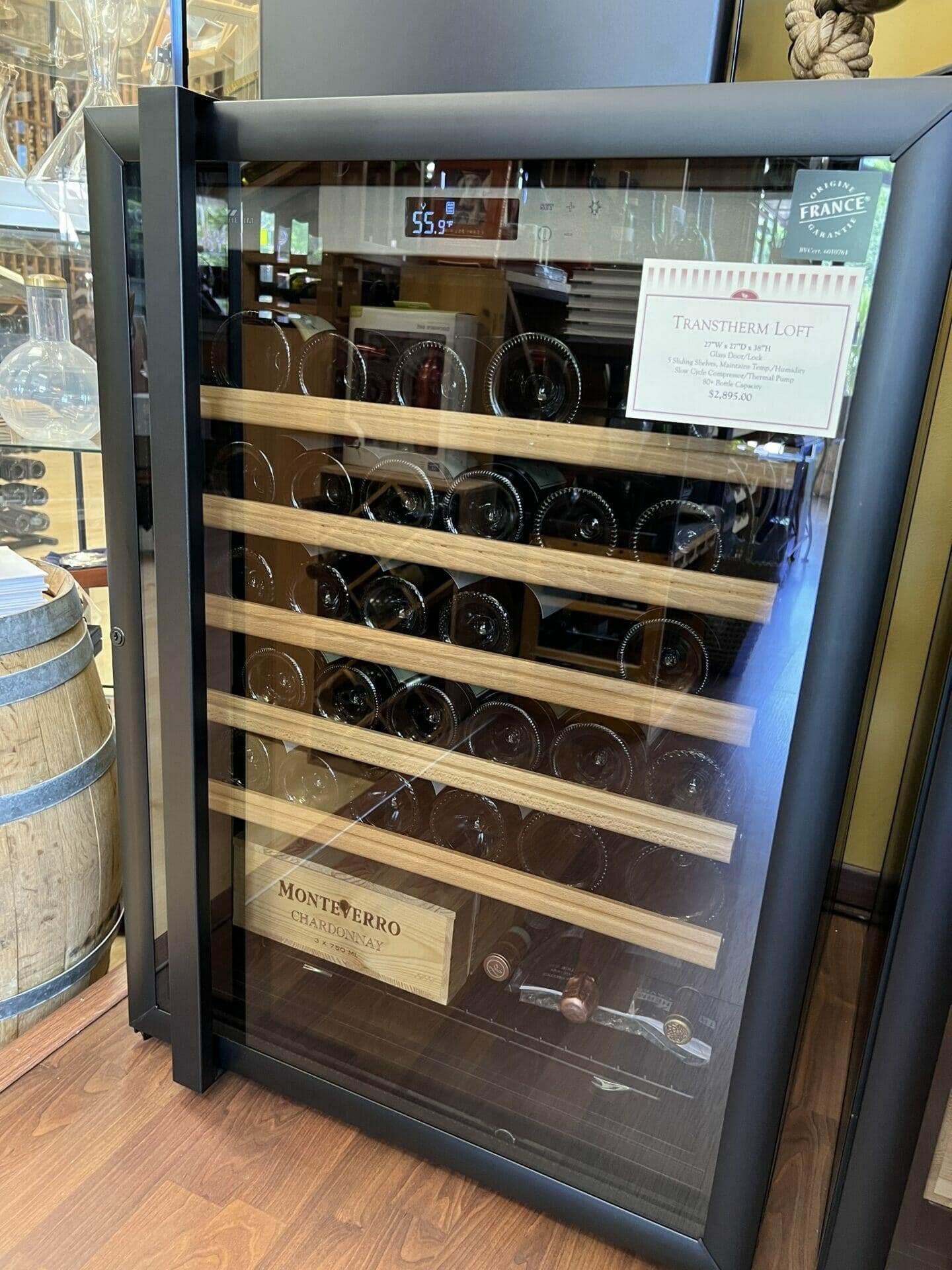 Transtherm Louvre wine cabinet in showroom with price tag, wood shelves holding bottles