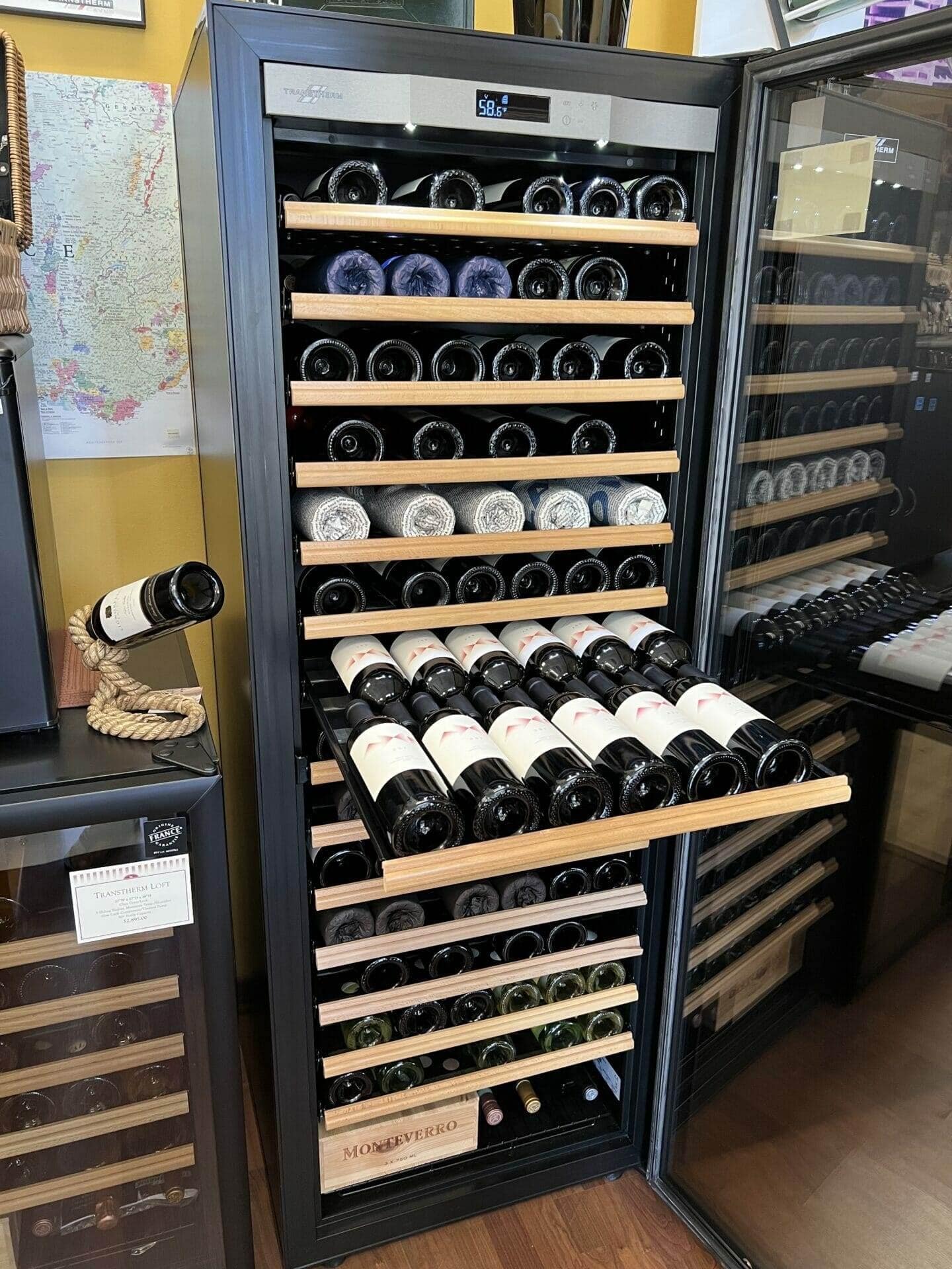 Transtherm wine cabinet fully loaded with red wine bottles in pulled-out wood drawer