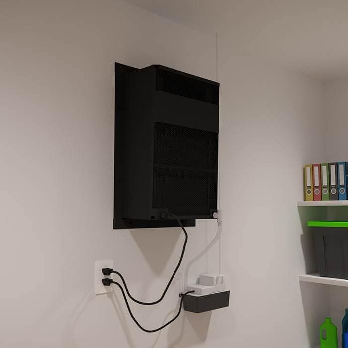 WhisperKOOL Extreme cooling unit wall-mounted above a power strip and outlet